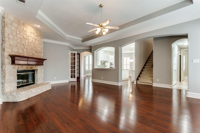 1121 Riverwalk Ct, Colleyville, TX 76034 - unfurnished living room featuring a raised ceiling, a ceiling fan, hardwood / wood-style flooring, baseboards, and a stone fireplace