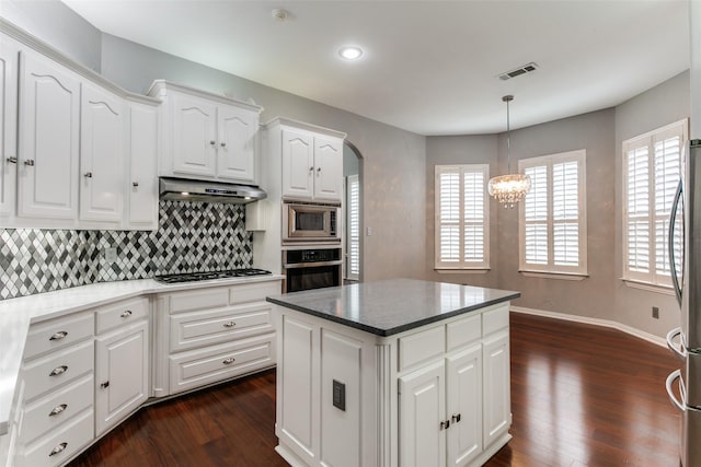 1121 Riverwalk Ct, Colleyville, TX 76034 - kitchen featuring under cabinet range hood, stainless steel appliances, dark wood finished floors, a chandelier, and backsplash
