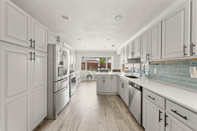 12212 Ridgefair Pl, Farmers Branch, TX 75234 - kitchen featuring stainless steel appliances, a textured ceiling, a sink, backsplash, and light countertops