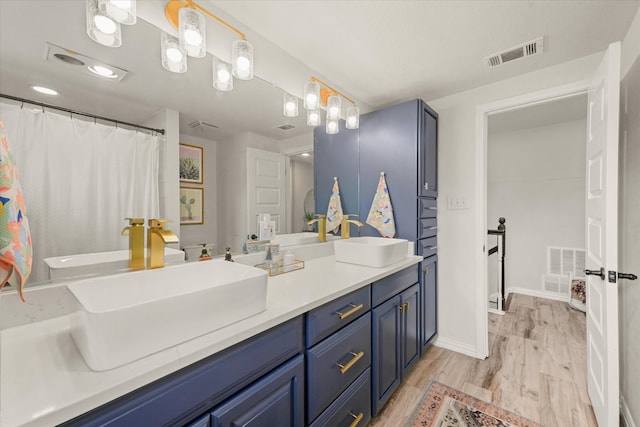 12212 Ridgefair Pl, Farmers Branch, TX 75234 - bathroom featuring wood finished floors, double vanity, baseboards, and a shower with curtain