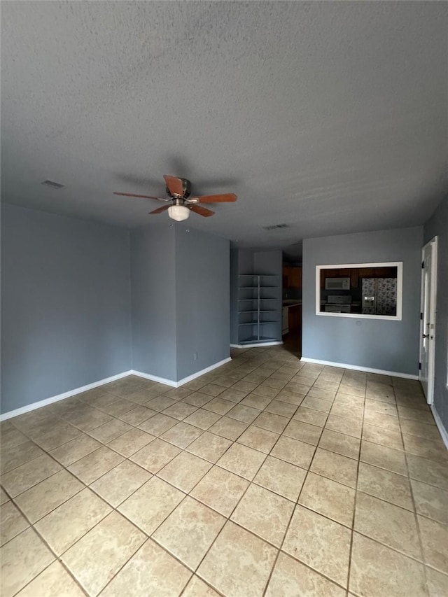 825 Willow Dr, Shreveport, LA 71118 - unfurnished room featuring light tile patterned flooring, ceiling fan, a textured ceiling, and baseboards