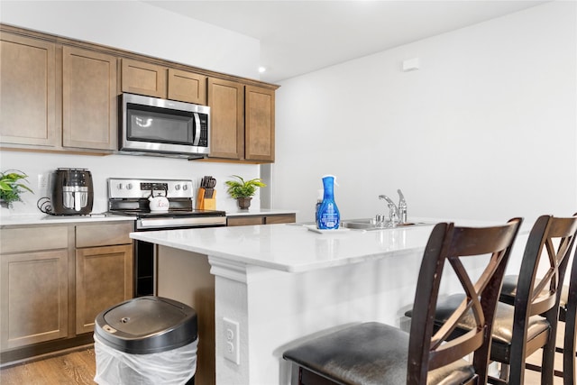 516 Wrangler Dr, Josephine, TX 75189 - kitchen featuring appliances with stainless steel finishes, a breakfast bar, recessed lighting, a sink, and wood finished floors