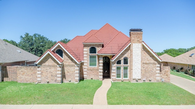 2709 Oak Point Dr, Garland, TX 75044 - view of front of home with a tiled roof, a chimney, a front lawn, and brick siding