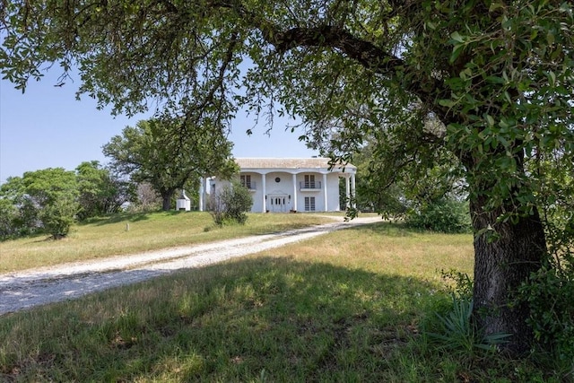 7750 Hanger Cutoff Rd, Fort Worth, TX 76135 - greek revival inspired property with a front yard, stucco siding, and driveway