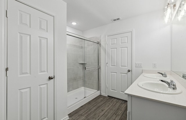 2608 Pecan Park Dr, Denton, TX 76208 - bathroom featuring a stall shower, wood finished floors, double vanity, and recessed lighting