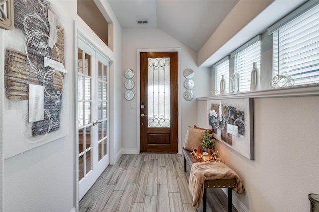 1208 Starlight Ave, Aubrey, TX 76227 - foyer entrance featuring vaulted ceiling, baseboards, light wood finished floors, and french doors