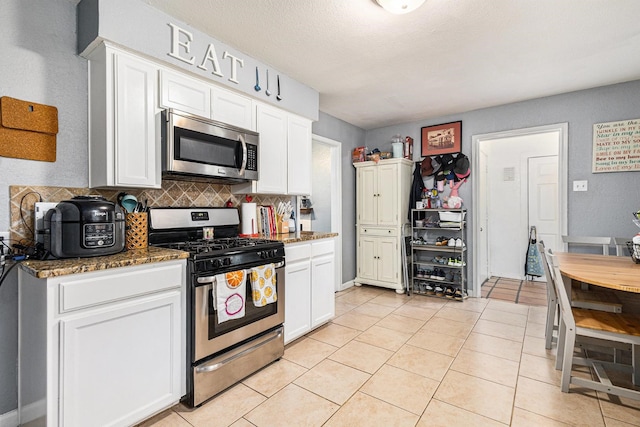 6217 Kentwood Pl, Fort Worth, TX 76112 - kitchen with appliances with stainless steel finishes, decorative backsplash, white cabinets, and dark stone countertops