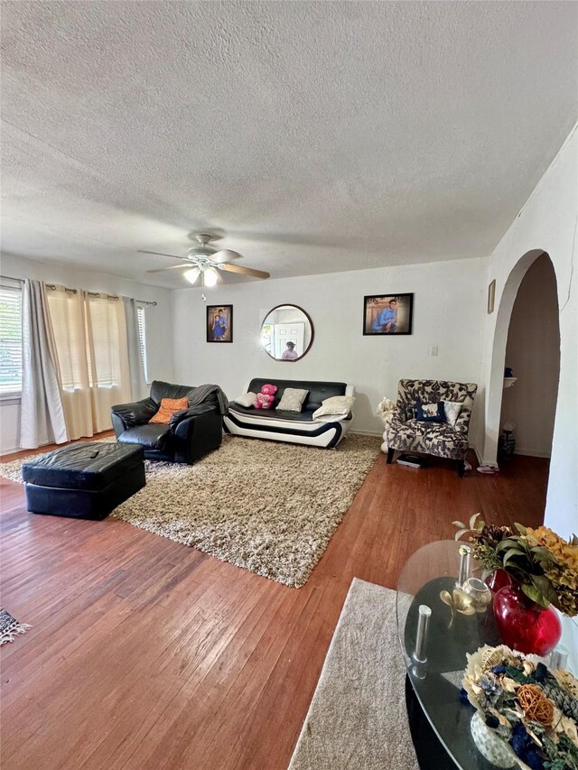 5521 Hightower St, Fort Worth, TX 76112 - living room with arched walkways, a textured ceiling, wood finished floors, and a ceiling fan