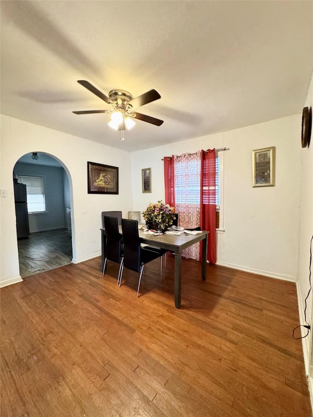 5521 Hightower St, Fort Worth, TX 76112 - dining room featuring arched walkways, a ceiling fan, wood finished floors, and baseboards