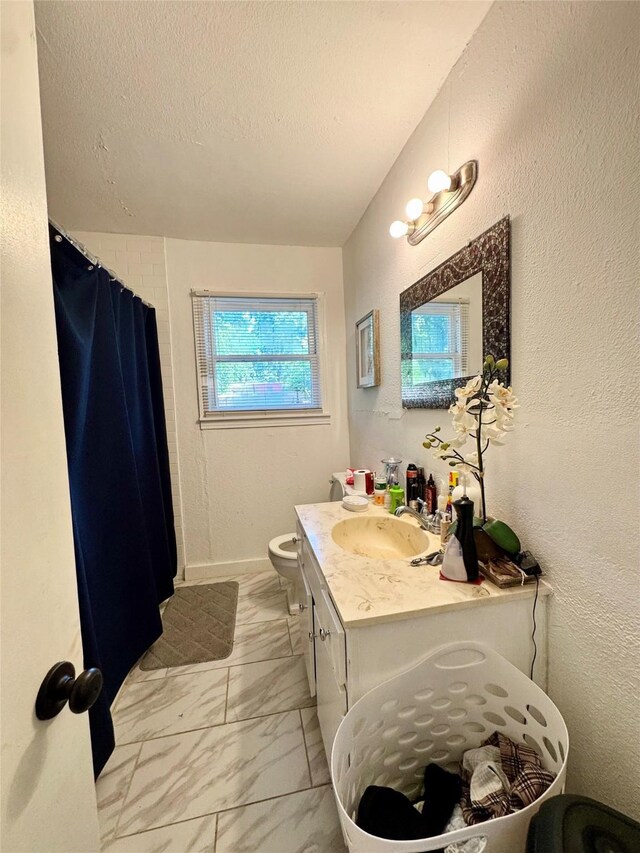 5521 Hightower St, Fort Worth, TX 76112 - full bathroom featuring marble finish flooring, vanity, toilet, a textured ceiling, and curtained shower