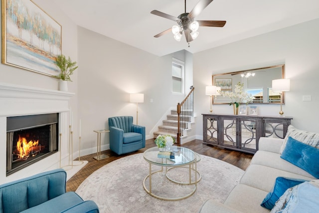 3234 Burke Dr, Royse City, TX 75189 - living room with a lit fireplace, stairs, a ceiling fan, baseboards, and wood finished floors