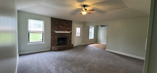 6436 Green Ridge Dr, Watauga, TX 76148 - unfurnished living room featuring ceiling fan, carpet flooring, a textured ceiling, baseboards, and a fireplace