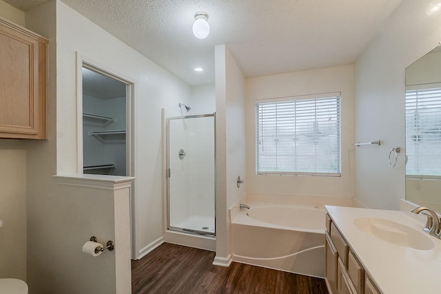 904 Havenbrook Dr, Arlington, TX 76001 - bathroom with wood finished floors, a shower stall, vanity, a garden tub, and a textured ceiling