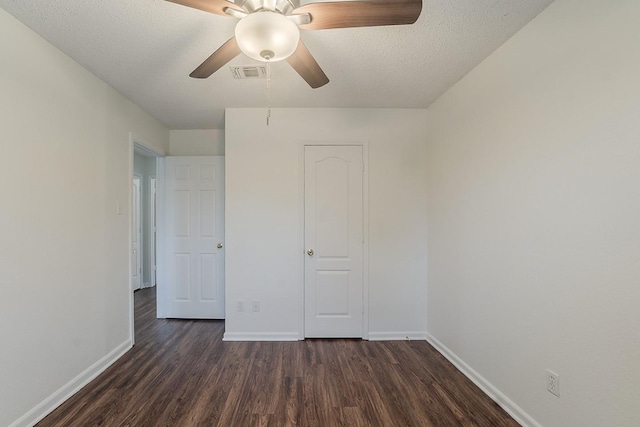 904 Havenbrook Dr, Arlington, TX 76001 - unfurnished bedroom featuring dark wood-style flooring, baseboards, and a textured ceiling
