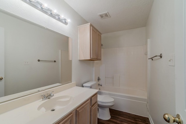 904 Havenbrook Dr, Arlington, TX 76001 - bathroom featuring wood finished floors, toilet, vanity, a textured ceiling, and bathtub / shower combination