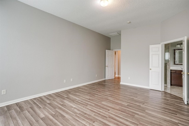 8016 Pretoria Pl, Fort Worth, TX 76123 - unfurnished bedroom featuring light wood-type flooring, a textured ceiling, ensuite bathroom, and baseboards