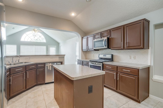 8016 Pretoria Pl, Fort Worth, TX 76123 - kitchen featuring appliances with stainless steel finishes, a sink, lofted ceiling, a center island, and decorative backsplash