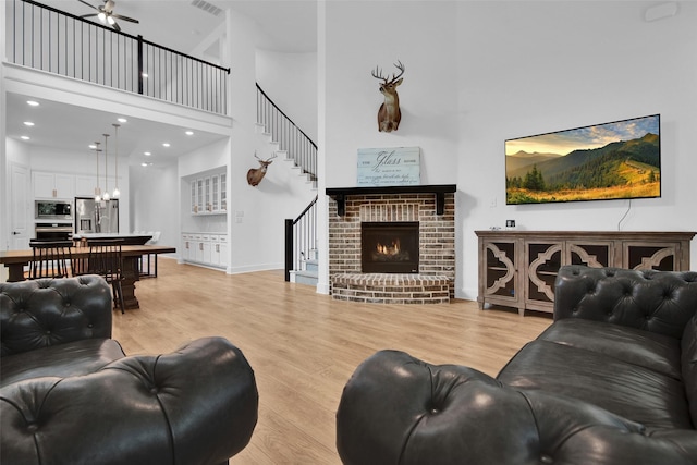 4166 Carter Ct, Denison, TX 75020 - living area with a high ceiling, light wood-style floors, a ceiling fan, stairway, and a chandelier