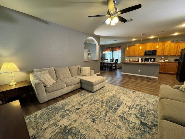 1621 Jasmine Trl, Savannah, TX 76227 - living room with dark wood-type flooring, a ceiling fan, and arched walkways
