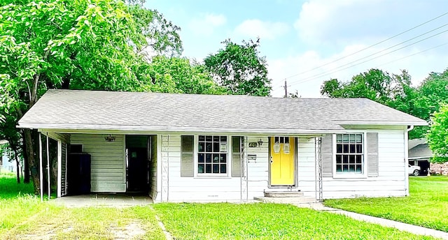 801 W State St, Groesbeck, TX 76642 - view of front facade with a front yard, entry steps, a shingled roof, and an attached carport