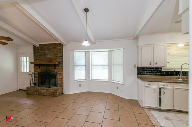9104 Rosedown Cir, Shreveport, LA 71118 - kitchen featuring a sink, dark countertops, white cabinets, a fireplace, and ceiling fan