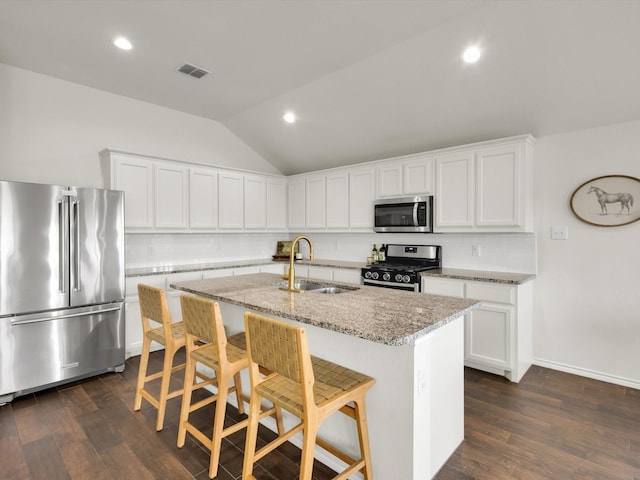 1519 Old Wichita Trl, Saginaw, TX 76131 - kitchen featuring appliances with stainless steel finishes, a sink, backsplash, lofted ceiling, and a kitchen island with sink