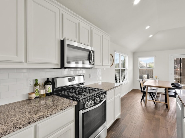 1519 Old Wichita Trl, Saginaw, TX 76131 - kitchen featuring stainless steel appliances, lofted ceiling, backsplash, white cabinets, and dark wood-type flooring