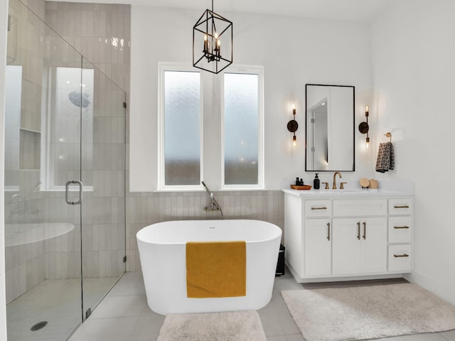1117 Mountain View Dr, Weatherford, TX 76087 - bathroom with a chandelier, a shower stall, a freestanding bath, vanity, and tile walls