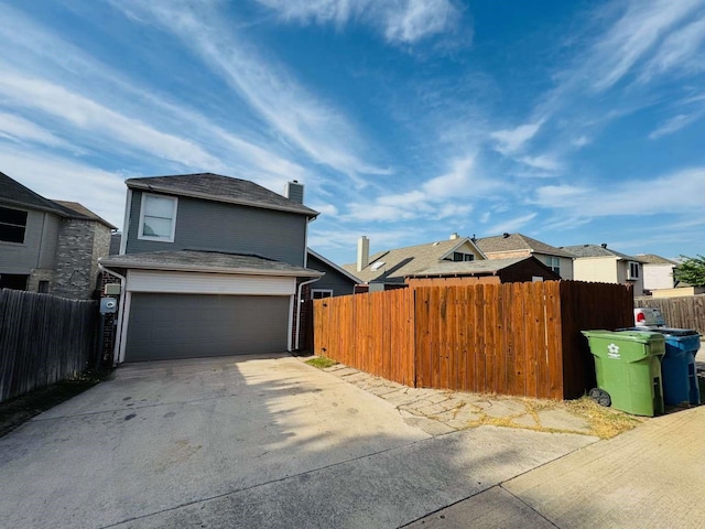 520 Timber Way Dr, Lewisville, TX 75067 - view of home's exterior with concrete driveway, a garage, and a chimney