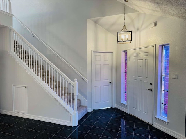 520 Timber Way Dr, Lewisville, TX 75067 - foyer entrance with stairway, dark tile patterned flooring, lofted ceiling, and baseboards