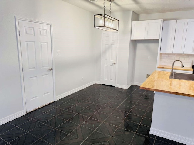 520 Timber Way Dr, Lewisville, TX 75067 - kitchen with a sink, butcher block countertops, white cabinetry, pendant lighting, and baseboards