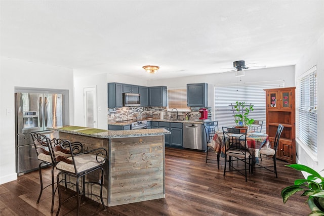 912 Thistle Cir, Allen, TX 75002 - kitchen featuring stainless steel appliances, a kitchen breakfast bar, dark wood finished floors, a kitchen island, and backsplash