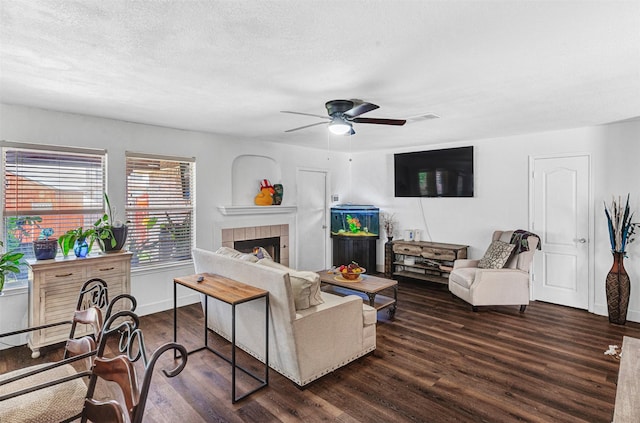 912 Thistle Cir, Allen, TX 75002 - living area featuring wood finished floors, a ceiling fan, a tiled fireplace, baseboards, and a textured ceiling