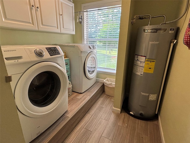 33 County Road 1131, Maud, TX 75567 - laundry room with electric water heater, light wood-style flooring, cabinet space, and washing machine and clothes dryer