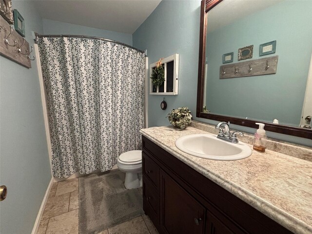 33 County Road 1131, Maud, TX 75567 - bathroom featuring baseboards, toilet, vanity, stone finish floors, and curtained shower
