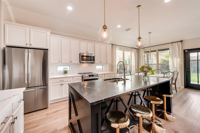 11701 Parade Dr, Frisco, TX 75036 - kitchen featuring appliances with stainless steel finishes, a sink, light wood finished floors, recessed lighting, and a breakfast bar