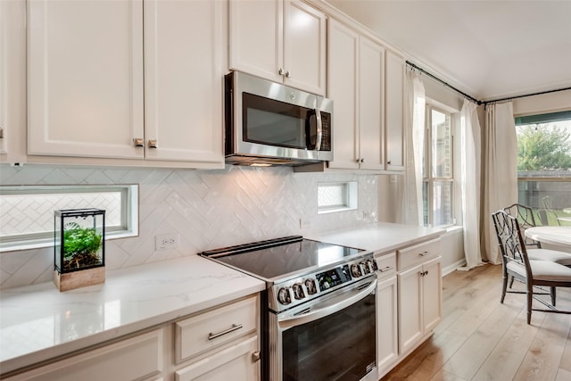 11701 Parade Dr, Frisco, TX 75036 - kitchen with stainless steel appliances, decorative backsplash, light stone countertops, light wood finished floors, and white cabinets