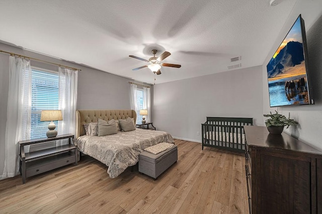 11701 Parade Dr, Frisco, TX 75036 - bedroom with light wood-style floors, ceiling fan, baseboards, and a textured ceiling