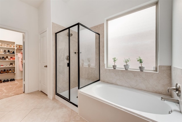 11701 Parade Dr, Frisco, TX 75036 - bathroom featuring a bath, a shower stall, tile patterned floors, and a walk in closet