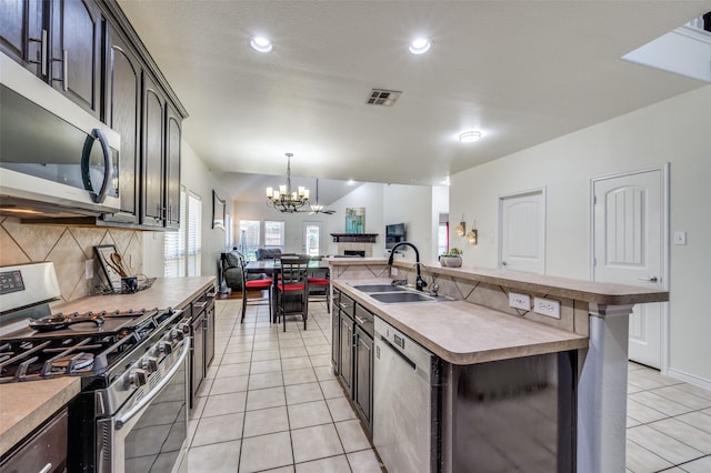 7812 Rancho De La Osa Trl, Mckinney, TX 75070 - kitchen featuring stainless steel appliances, a sink, open floor plan, a chandelier, and decorative backsplash