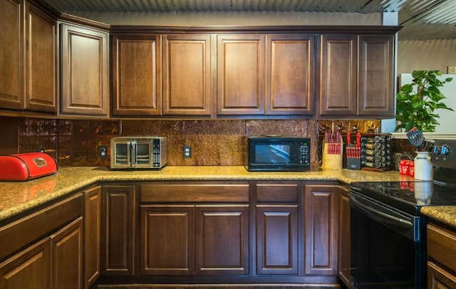 700 Magnolia St, Teague, TX 75860 - kitchen with black appliances, decorative backsplash, and light countertops