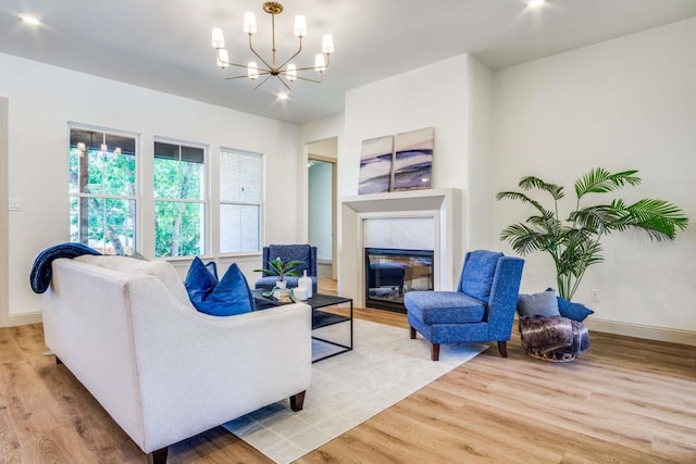 407 Baldwin Dr, Joshua, TX 76058 - living room with light wood finished floors, a chandelier, a glass covered fireplace, and baseboards
