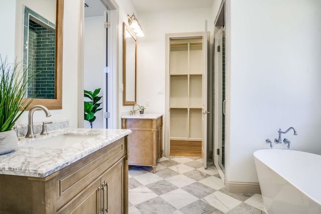 407 Baldwin Dr, Joshua, TX 76058 - bathroom with two vanities, a stall shower, a freestanding tub, a spacious closet, and baseboards