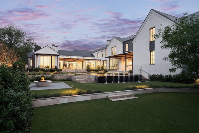 5531 Walnut Hill Ln, Dallas, TX 75229 - yard at dusk featuring a fire pit, a lawn, and a patio