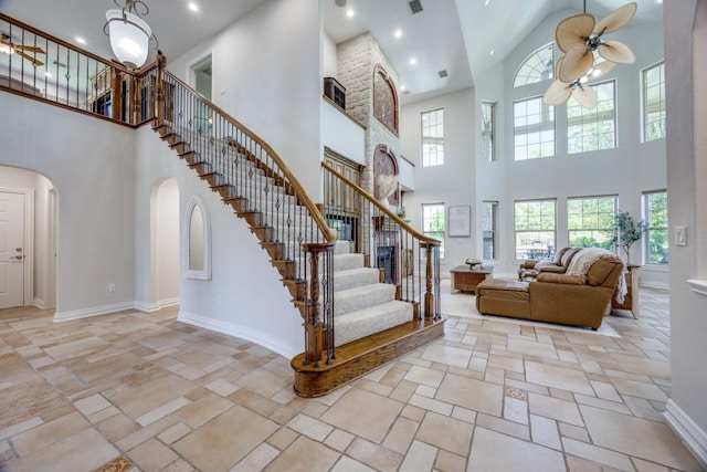 87 Eagle Chase Ln, Pottsboro, TX 75076 - stairs featuring a ceiling fan, a towering ceiling, arched walkways, healthy amount of natural light, and baseboards