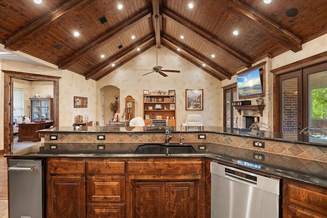 3712 Lonesome Creek Rd, Granbury, TX 76049 - kitchen featuring dishwasher, wood ceiling with exposed beams, a sink, arched walkways, and a stone fireplace