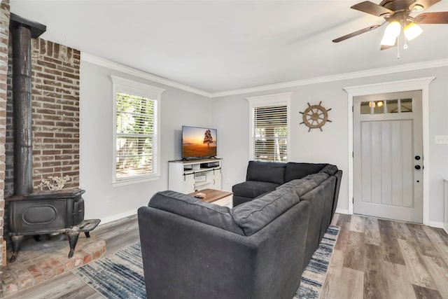 6505 Oakwood Lake Ct, Granbury, TX 76049 - living room with a wood stove, wood finished floors, ornamental molding, ceiling fan, and baseboards