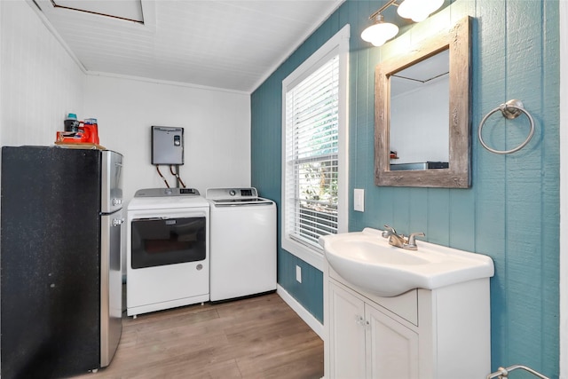 6505 Oakwood Lake Ct, Granbury, TX 76049 - laundry room featuring washer and clothes dryer, light wood finished floors, and ornamental molding