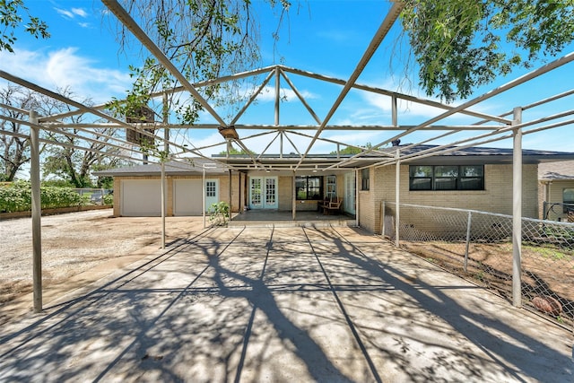 309 School House Rd, Paradise, TX 76073 - back of property with driveway, french doors, an attached garage, brick siding, and a patio area