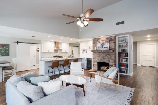4018 Crown Shore Dr, Dallas, TX 75244 - living room with a barn door, high vaulted ceiling, ceiling fan, a brick fireplace, and wood finished floors